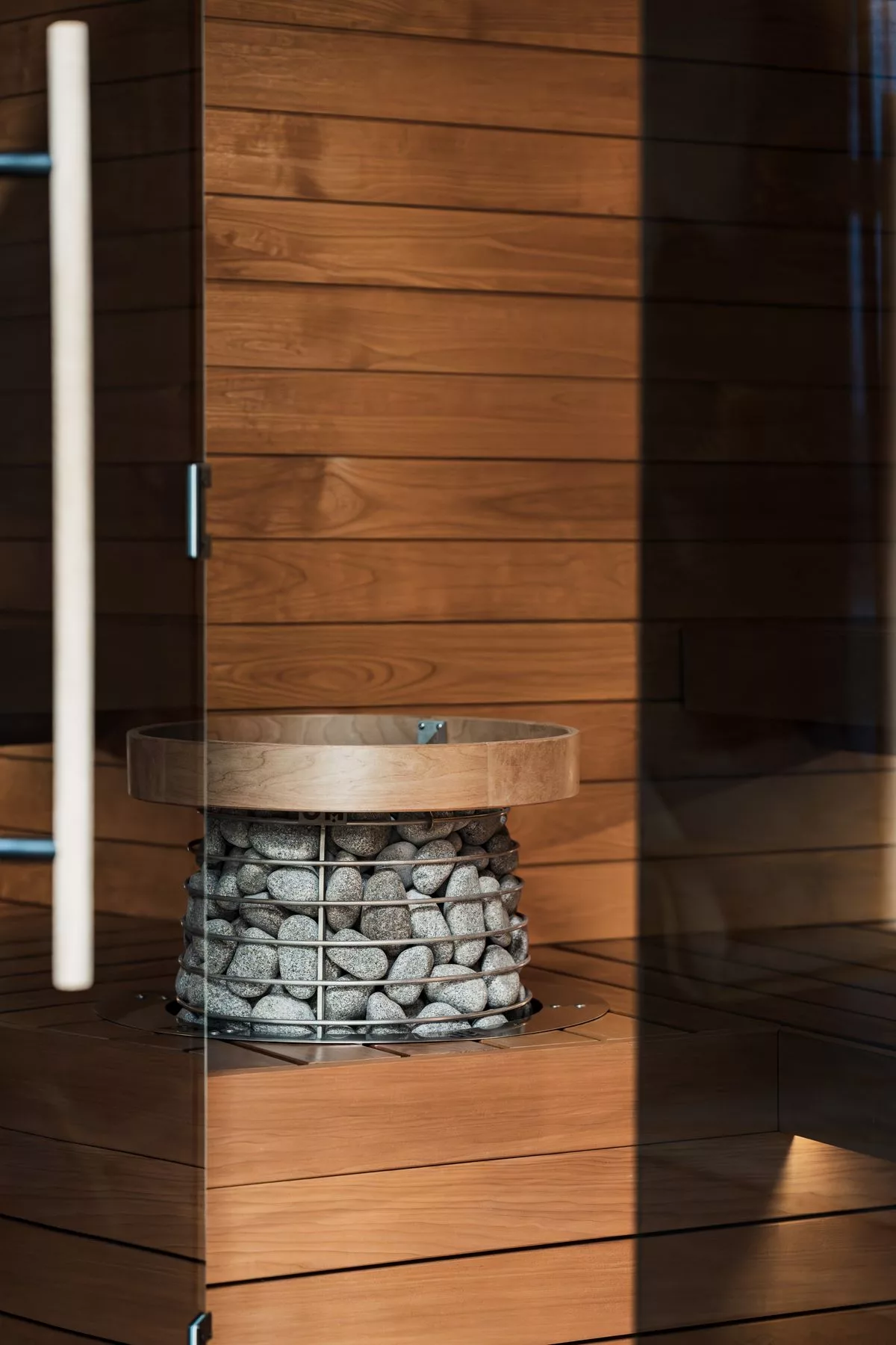 Sauna finlandese con interni in legno caldo e stufa con pietre